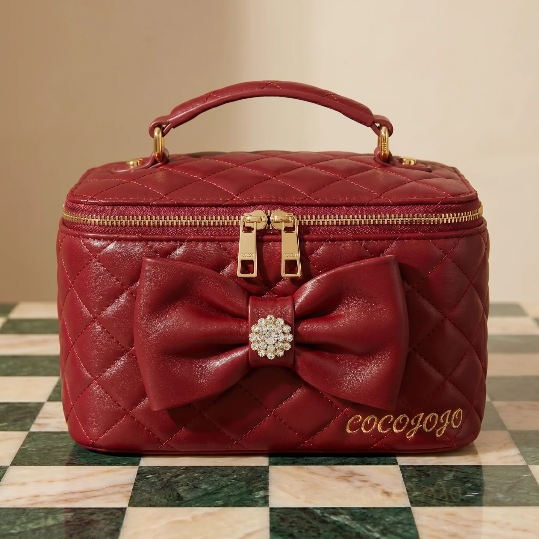 Red quilted COCOJOJO vanity bag with gold lettering